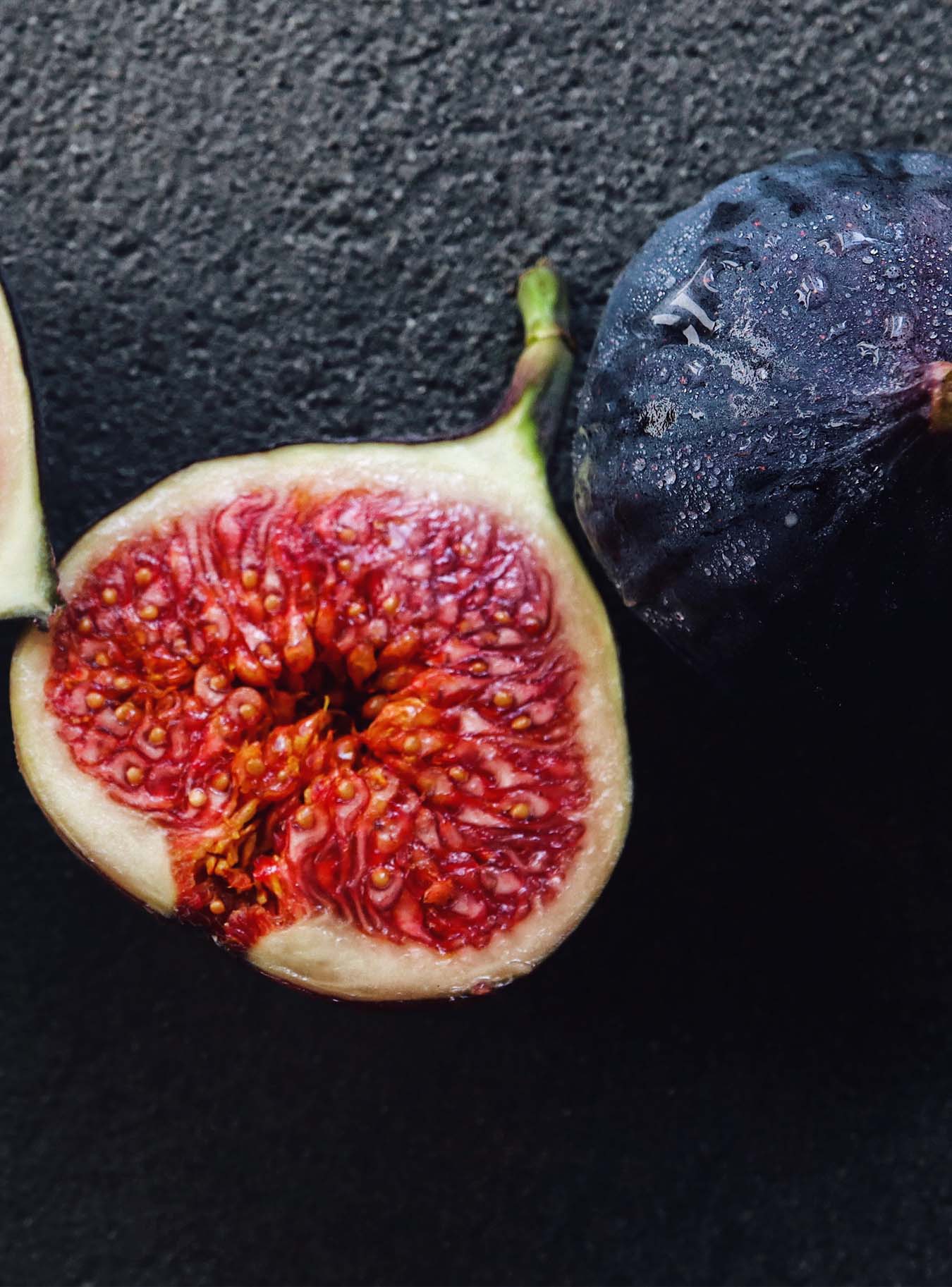 halved fig on black plate