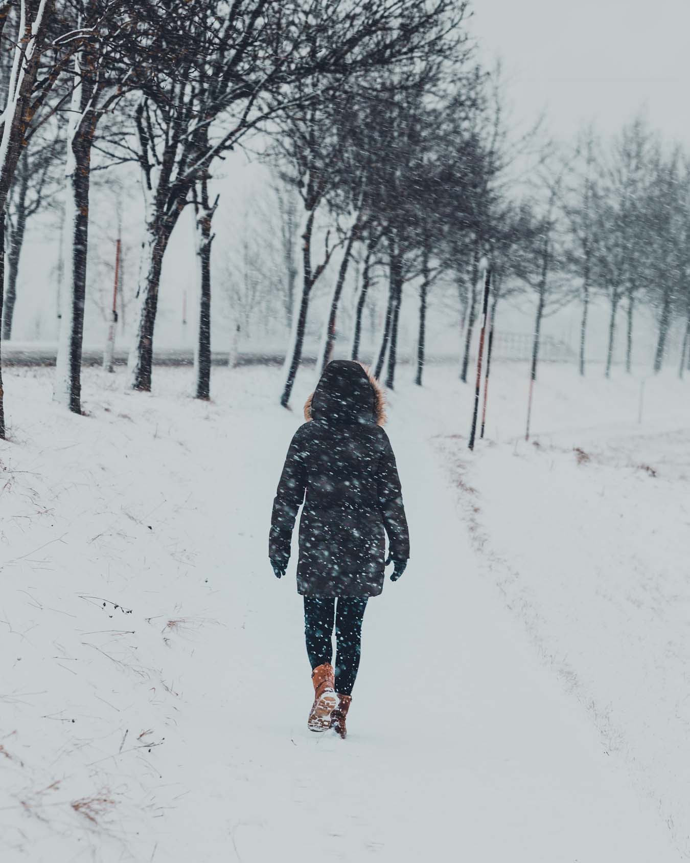 Eine Person mit warmer Winterbekleidung trotzt dem Schneesturm
