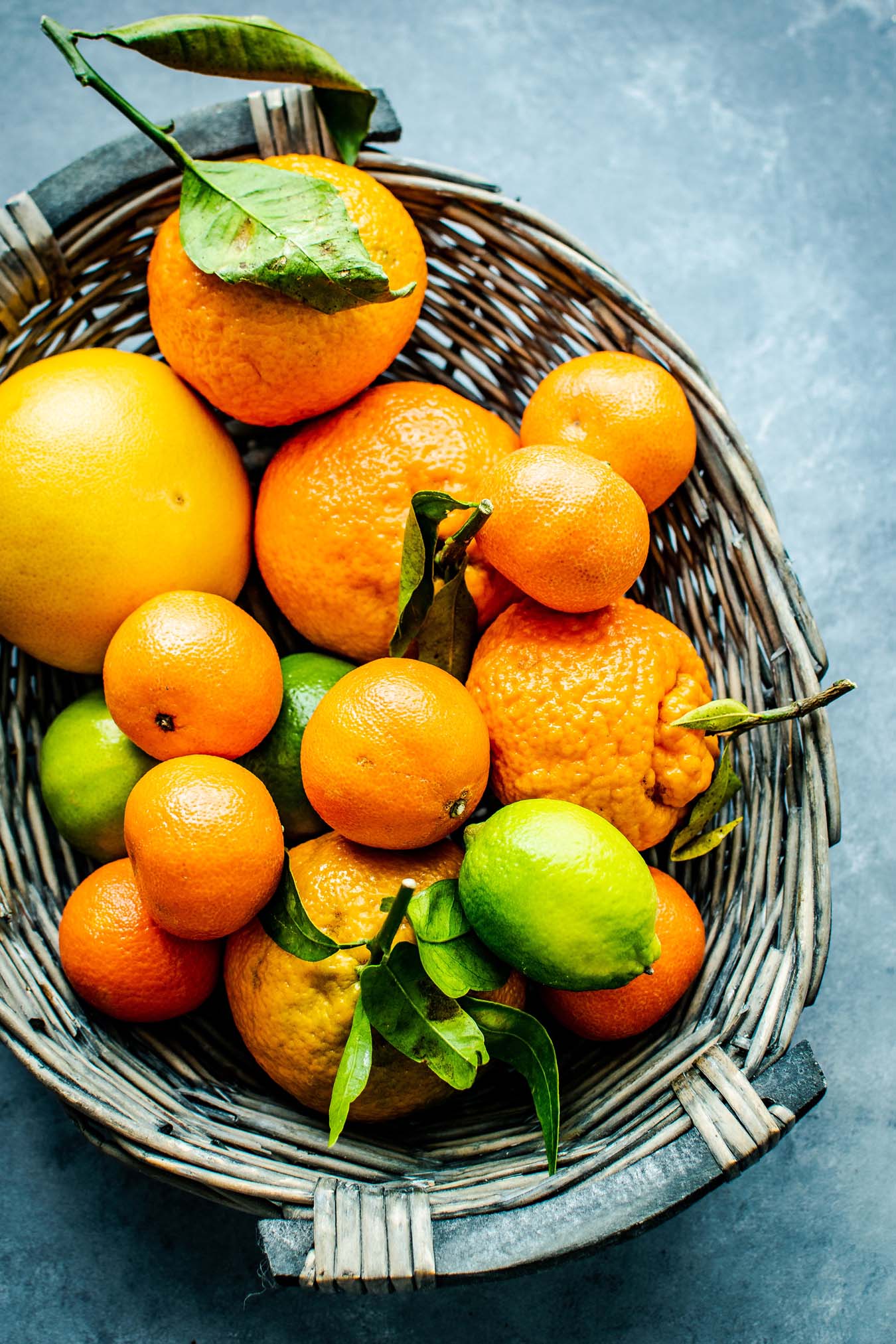 Orangen- und Zitronenfrüchte in grauem Weidenkorb