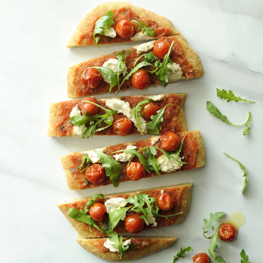 pizza with cherry tomatoes, cashew-mozarella and aragula