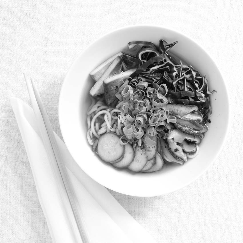 ramenbowl with noodles, red cabbage, mushrooms and tofu - wooden chopsticks next to it