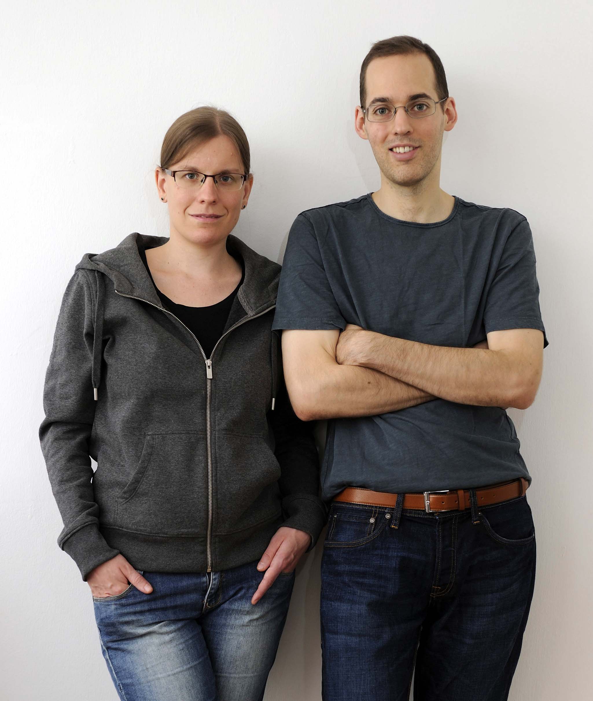 Thomas and Ann-Katrin in casual outfit standing in front of white wall