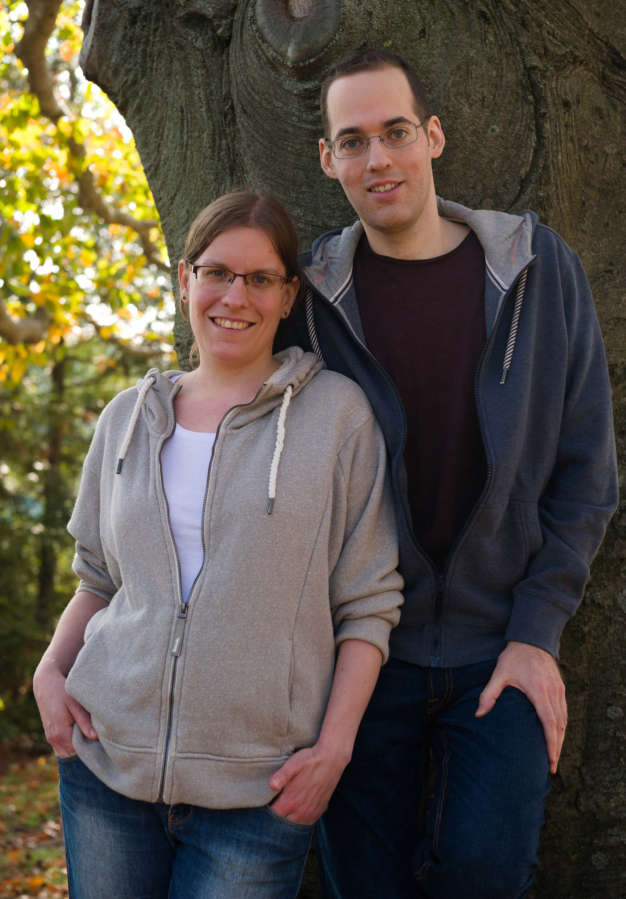 Thomas und Ann-Katrin im lässigen Outfit an Baum lehnend